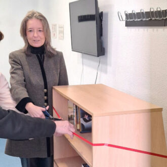 La concejala de Salamanca, Cayetana Hernández de la Riva, junto a socios del CMM La Guindalera cortando una cinta roja en la inauguración del punto de intercambio de libros