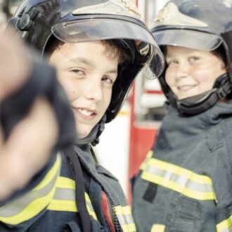 Dos niños vestidos con uniformes de bombero en una de las formaciones impartidas por emergencias de Madrid
