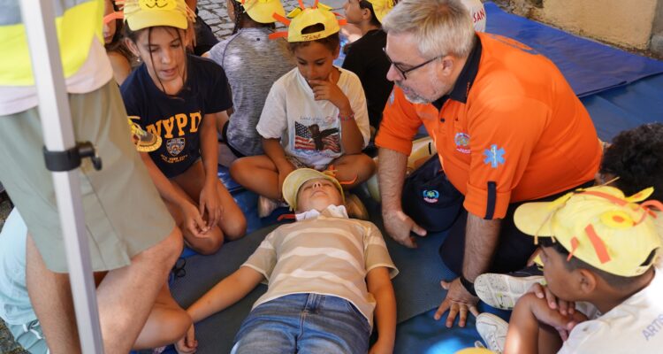 Un miembro de SAMUR-PC enseña Primeros Auxilios a un grupo de niños