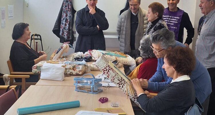 Martínez Páramo visitando los talleres del CMM donde se aprecia sentados a socios y socias haciendo encaje de bolillos