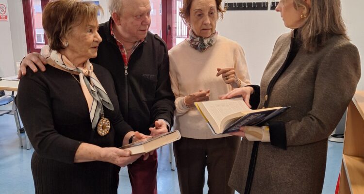 La concejala de Salamanca, Cayetana Hernández de la Riva, junto a socios participantes del punto de intercambio de libros comentando un ejemplar