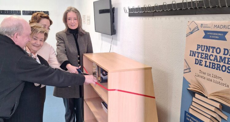 La concejala de Salamanca, Cayetana Hernández de la Riva, junto a socios del CMM La Guindalera cortando una cinta roja en la inauguración del punto de intercambio de libros