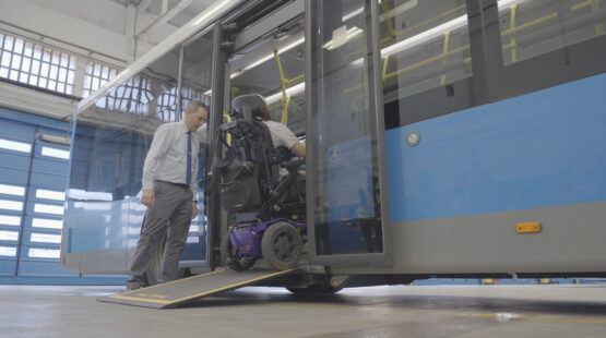 Una persona con discapacidad en la movilidad utilizando la rampa de un autobús
