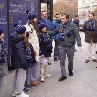 Almeida con un grupo de niños frente al bus de la Navidad de EMT Madrid