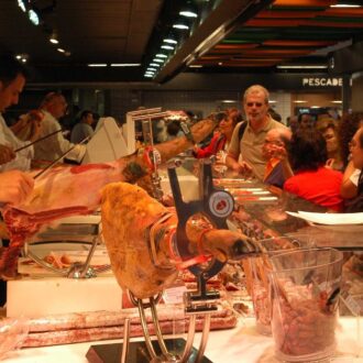 Un profesional de la hostelería manipulando alimento en el Mercado Municipal de San Antón