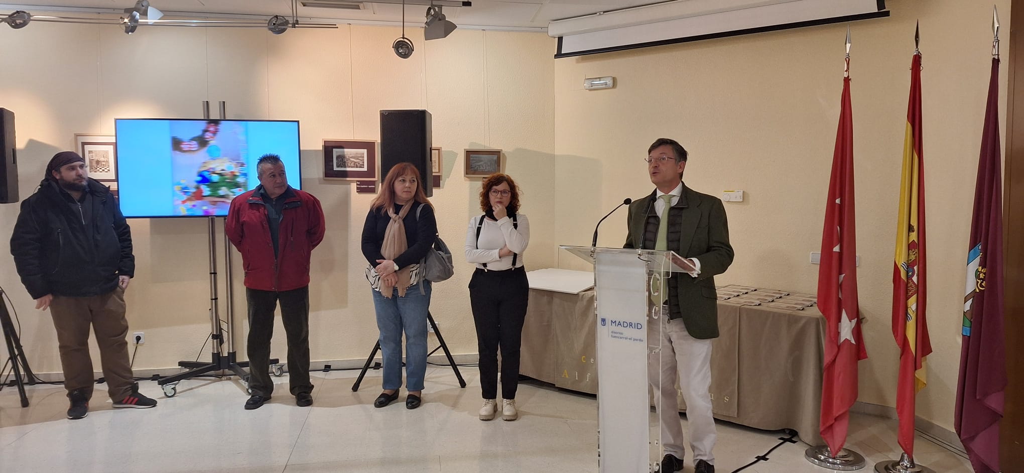 El concejal de Fuencarral-El Pardo, José Antonio Martínez Páramo, junto al jurado del certamen en un atril hablando de pie