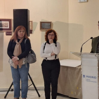 Martínez Páramo con el jurado del Certamen de belenes escolares del distrito 2025 hablando de pie en el atril