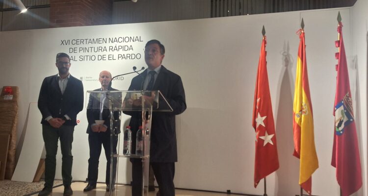 El concejal de Fuencarral-El Pardo, José Antonio Martínez Páramo, en la entrega de premios del certamen, donde se le ve en el atril dando el discurso, con una trasera corporativa del certamen y las banderas institucionales de fondo