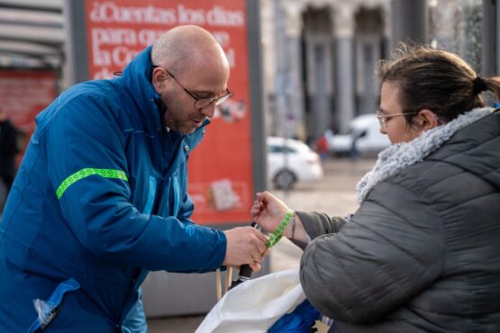 Personal de EMT Madrid entregando pulsera verde a ciudadana