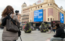Una mujer toma una fotografía en la plaza del Callao