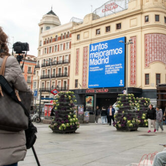 Una mujer toma una fotografía en la plaza del Callao
