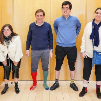 Almeida, con calcetines desparejados, posa junto a miembros de la fundación Down Madrid, en el palacio de Cibeles