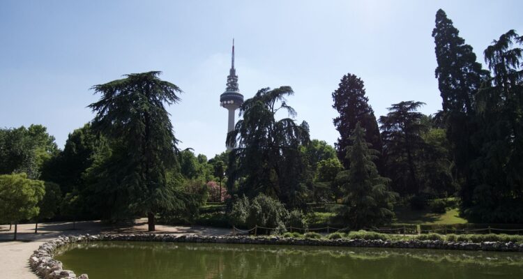 Estanque del Parque de la Fuente del Berro con vegetación y vistas del skyline de Madrid