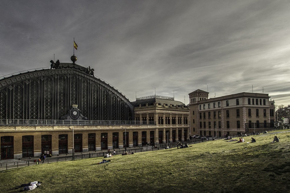Personas participando en una visita guiada de Pasea Madrid ante un monumento histórico