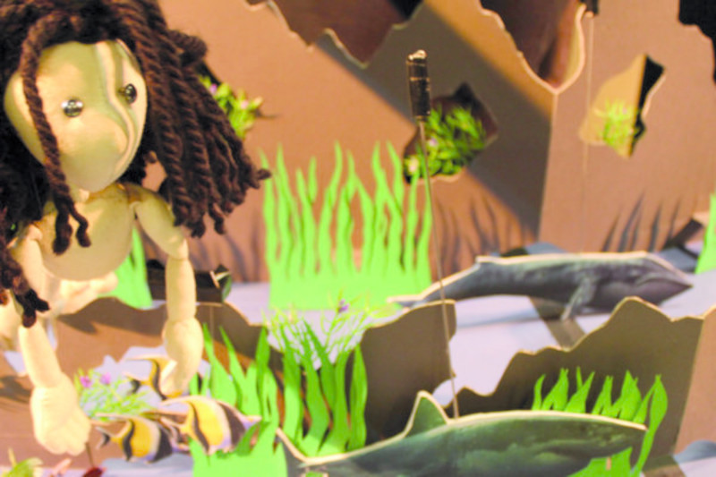 Escenografía de títeres con figura de niña en un entorno natural