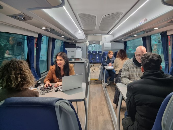 Orientadores municipales atienden a varias personas en el interior del Bus del Empleo