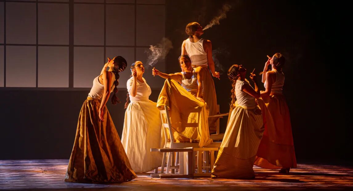 Bailarinas en escena con iluminación cálida durante el espectáculo de danza contemporánea Humo