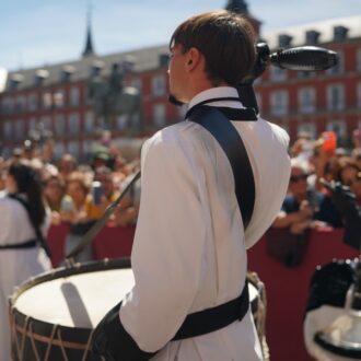 Un componente de la tamborrada, en primer plano, toca en la Plaza mayor de Madrid el Domingo de Resurrección