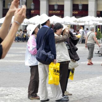 Turistas asiáticos toman fotografías en la Plaza Mayor