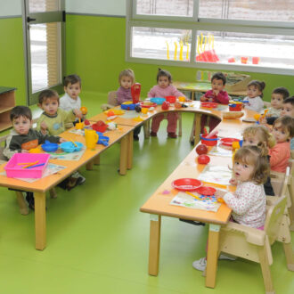 alumnos de escuela infantil sentados en una mesa
