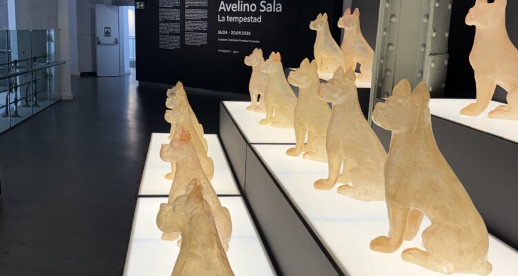 Esculturas de perros iluminadas en una sala de exposición contemporánea