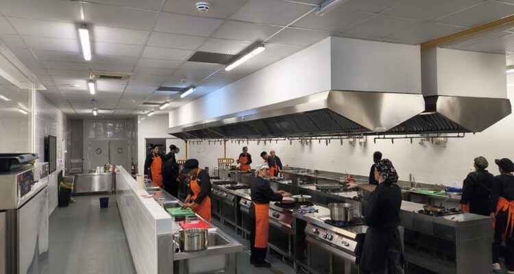 Alumnos de la Escuela Municipal de Hostelería y Alimentación de Madrid practicando el servicio de mesa con platos y fruta.