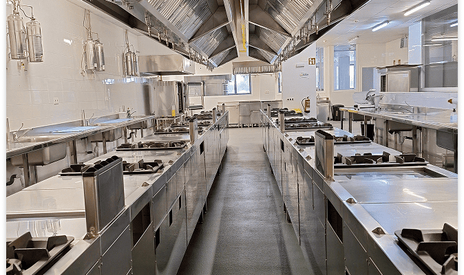 Cocina profesional equipada con fogones industriales en la Escuela Municipal de Hostelería y Alimentación de Madrid.