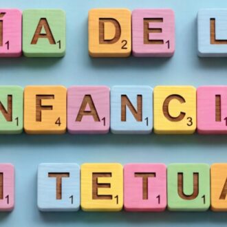 Imagen promocional del Día de la Infancia en Tetuán con letras de colores sobre fondo azul formando el título del evento.