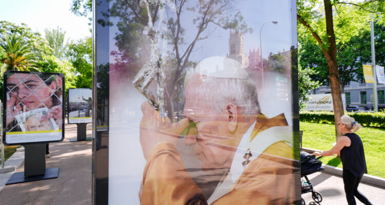 Primer plano de un soporte con fotografía de Juan Pablo II besando una cruz durante su visita a Madrid