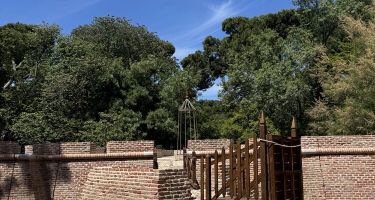 Fortín de ladrillo rojo con foso y puerta de madera en el parque de El Capricho de Madrid