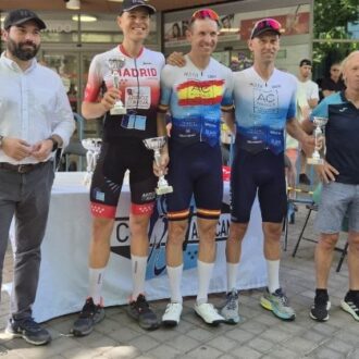 Niño posa con los ciclistas ganadores tras darles los trofeos