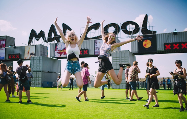 Imagen de archivo de la entrada al festival Mad Cool con dos chicas en primer plano saltando