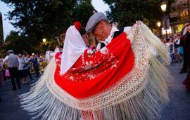 Pareja de chulapos bailando con mantón de Manila rojo durante la Verbena de la Paloma en Madrid