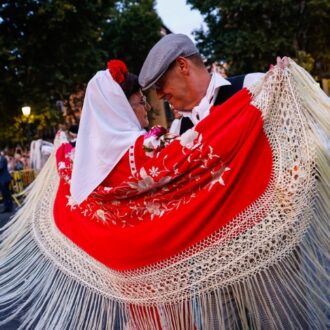 Pareja de chulapos bailando con mantón de Manila rojo durante la Verbena de la Paloma en Madrid