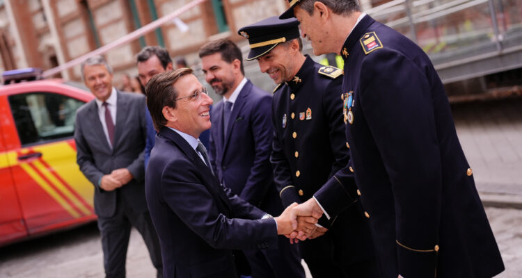 El alcalde saluda a oficiales de bomberos a la llegada al acto