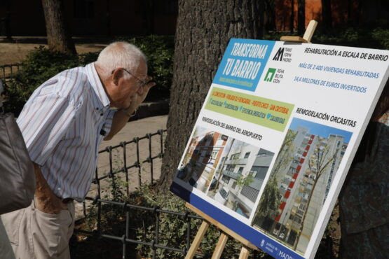 Ciudadano mirando cartela Plan Transforma tu Barrio en Orcasitas