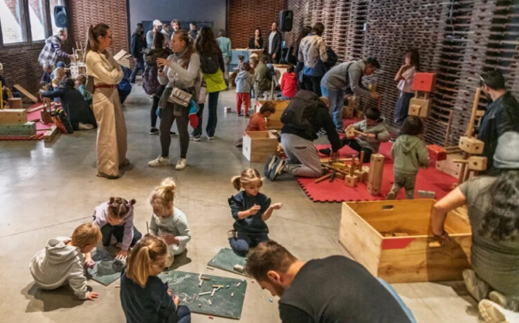 Niñas y niños jugando con las piezas de madera del juego 'Gran Convoy' en Matadero