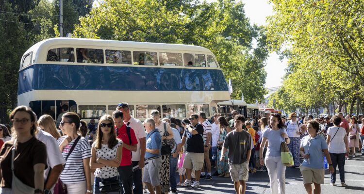 Participantes de la Fiesta de la Movilidad pasean entre los autobuses expuestos en el paseo del Prado