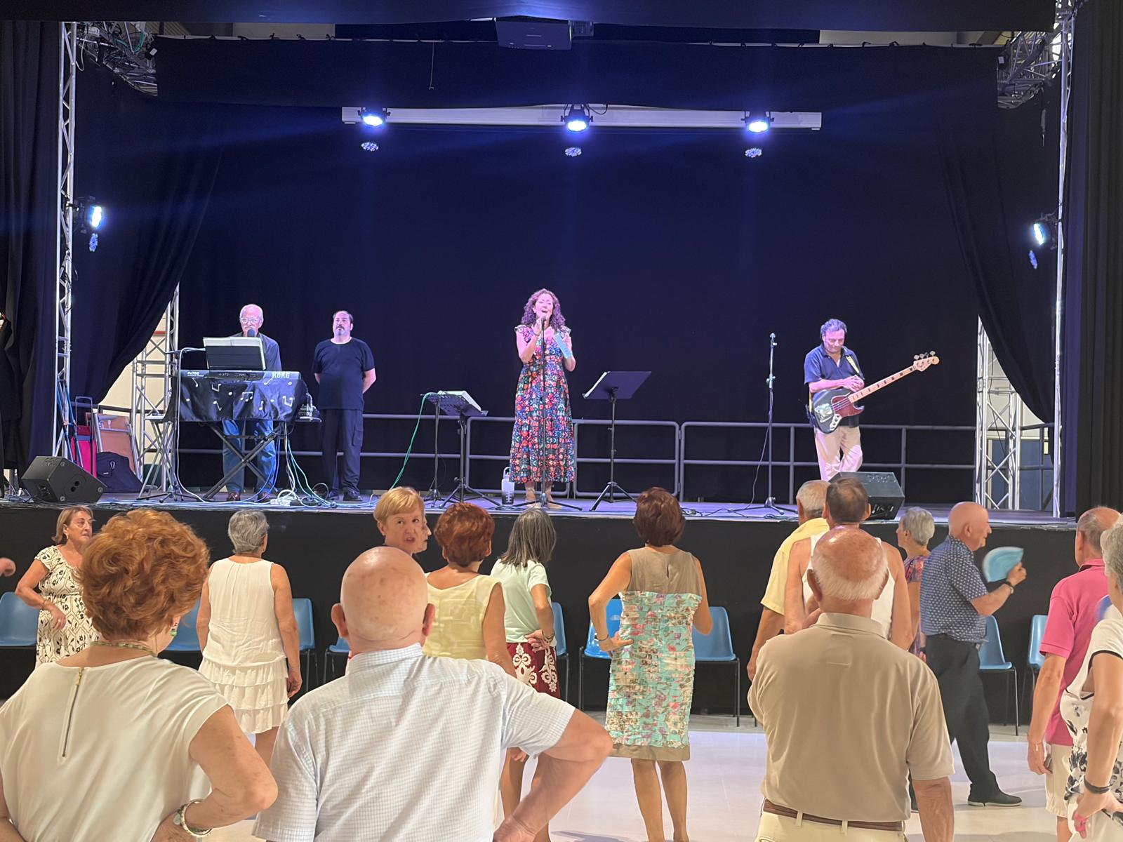 La concejala de Arganzuela, Lola Navarro, en la inauguraci&oacute;n de las Fiestas de La Melonera, sobre el escenario y acompa&ntilde;ada por los componentes del grupo que ofrecer&aacute; un concierto a continuaci&oacute;n