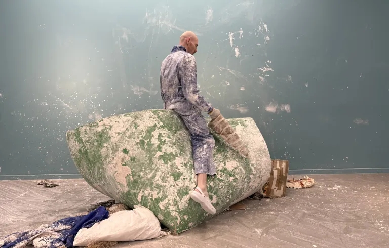 Imagen de la obra en la que un hombre está subido en una pieza abstracta